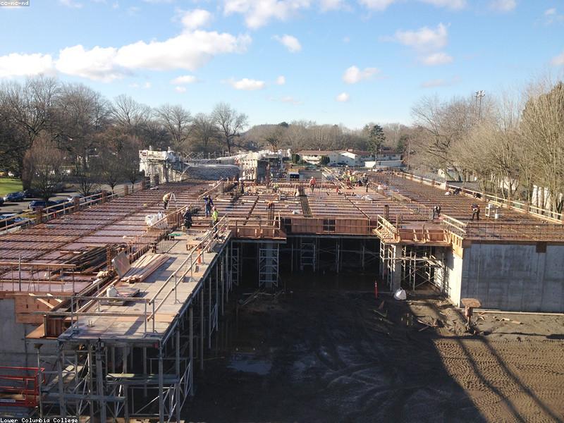 Fresh concrete being screeded on an elevated deck at sunrise.