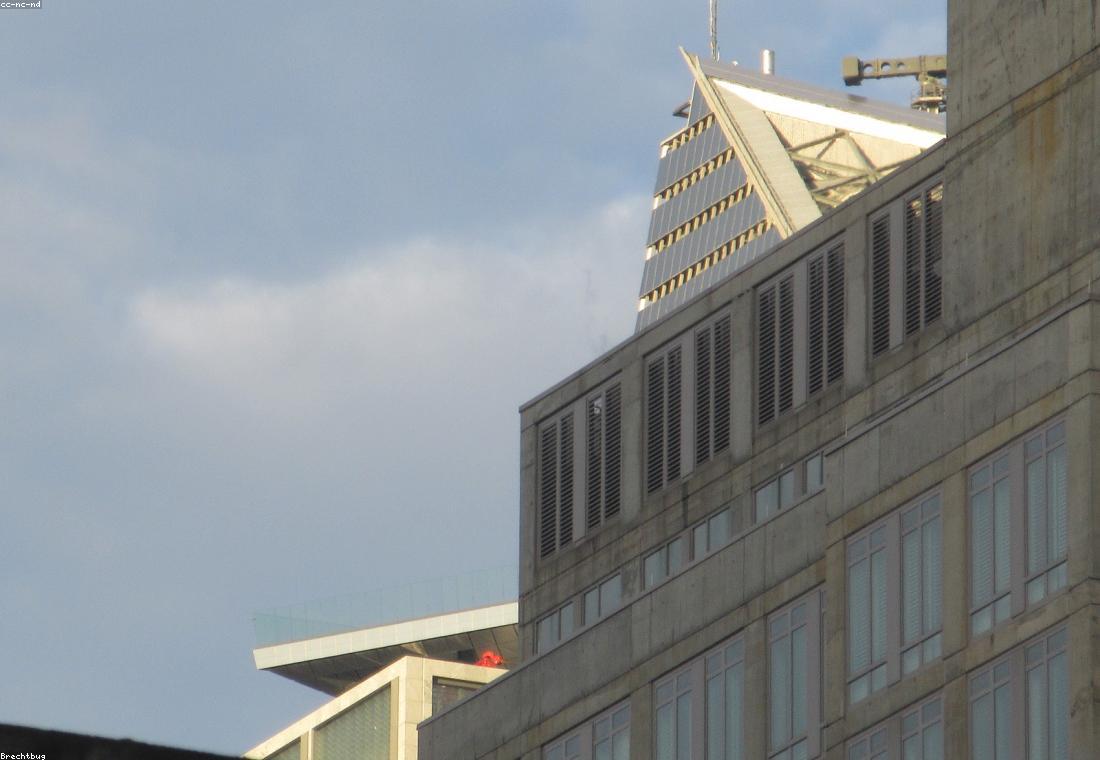 A tower crane silhouetted against a concrete core at dawn.